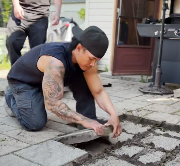 Seal-Tech Solutions owner setting interlock pavers by hand